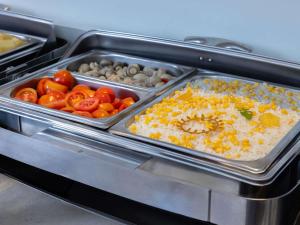 a tray of food with tomatoes and other vegetables at Ibis Lagos Ikeja in Ikeja +27 photos