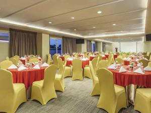 a conference room with tables and chairs and tablesktop at Ibis Surabaya City Center in Surabaya