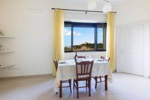 jadalnia ze stołem i krzesłami oraz oknem w obiekcie Dependance Le Tajate by BarbarHouse w mieście Casarano
