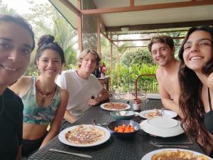 a group of people sitting at a table with food at Karandi Hostel Uvita in Uvita +43 photos