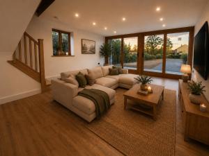 a living room with a couch and a tv at Blackberry Barn in Baltonsborough