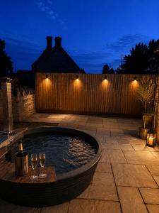 a pool with wine glasses in a backyard at night at Blackberry Barn in Baltonsborough