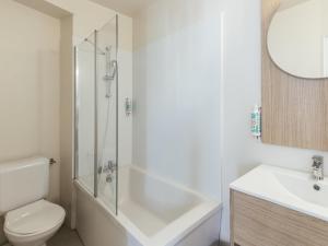 a bathroom with a shower and a toilet and a sink at Aparthotel Adagio Access Paris La Villette in Paris