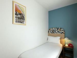 a bedroom with a bed and a picture on the wall at Aparthotel Adagio Access Paris La Villette in Paris +59 photos