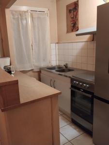 a small kitchen with a sink and a stove at Le rdv incontournable in Nancy