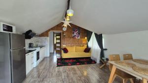 a kitchen and living room with a yellow couch at GONTA kottage - БАСЕЙН,ЧАН - Джакузі in Slavske