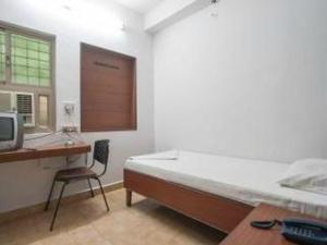 a bedroom with a bed and a desk and a computer at SRC Mahal in Killai