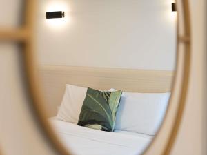 a mirror reflection of a bed with a pillow at Mantra Central Wellington in Wellington
