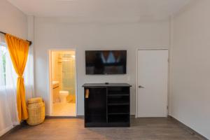 a living room with a television on a wall at "Hotel Relax" in Las Pozas