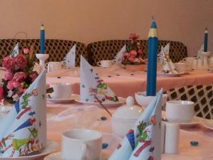 a table with blue candles and cups and plates on it at Richzenhainer-Hof in Waldheim