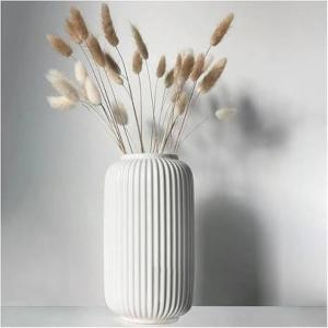 a white vase with a bunch of flowers in it at Le rdv incontournable in Nancy