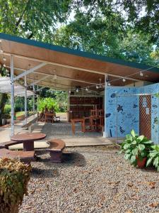 a pavilion with benches and tables in a park at Karandi Hostel Uvita in Uvita