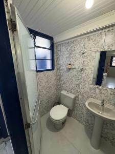 a bathroom with a toilet and a sink at Suite Simples PRIVATIVA in Diamantina