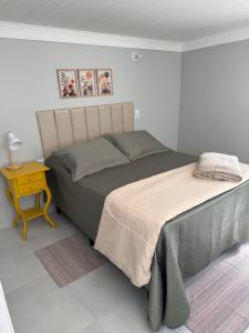 a bedroom with a large bed and a night stand at Suite Simples PRIVATIVA in Diamantina