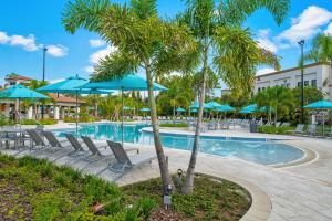 a pool at a resort with chairs and umbrellas at Vista Cay Luxury Loft in Orlando