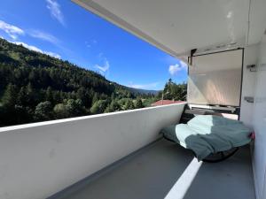 a balcony with a bed and a view of the mountains at Le Balcon - La Bresse in La Bresse