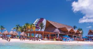 a resort on a beach with chairs and umbrellas at Mia Reef Isla Mujeres - All Inclusive Resort in Isla Mujeres +64 photos