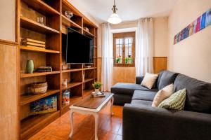 a living room with a couch and a tv at Casa Eloah in Antequera