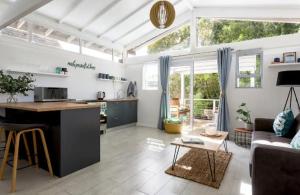 a kitchen and living room with a couch and a table at Kai Cottage in Bergvliet