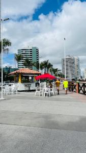 a group of tables and chairs with umbrellas and buildings at Ocean Tower in São Luís