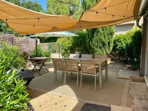 a table and chairs under an umbrella on a patio at La Bergerie De Vaison in Entrechaux
