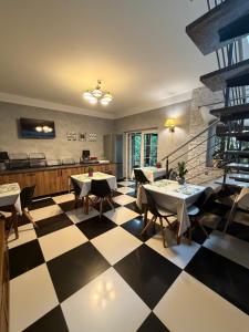 a restaurant with tables and chairs on a checkered floor at Arkadia Gościniec-klima,parking,ogród in Opole