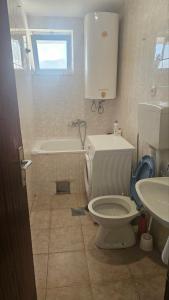 a bathroom with a toilet and a tub and a sink at Apartman Andrej in Bar