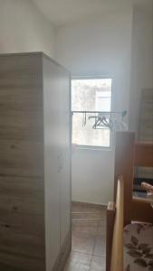 a white cabinet in a room with a window at Apartman Andrej in Bar