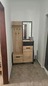 a wooden dresser in a room with a mirror at Apartman Andrej in Bar