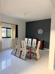 a dining room with a glass table and chairs at Oikos Residencial in Chimoio