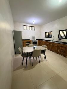 a kitchen with a table and chairs in a room at Oikos Residencial in Chimoio +13 photos