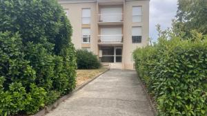 a walkway in front of a building with bushes at Grand T2 calme avec parking privé à Toulouse in Toulouse