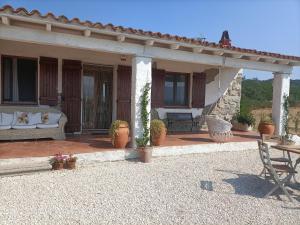 a porch of a house with a couch and a table at Funtana e Caddos apartment in Berchidda