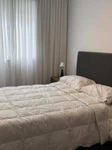 a white bed in a bedroom with a window at luxury apart 1 in Villa María