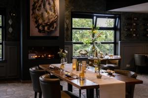 a dining room with tables and chairs and a fireplace at Hof van Alexander Boutiquehotel in Renesse