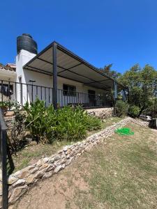 a building with a stone path in front of a house at Casa Familiar Villa Carlos Paz in Villa Carlos Paz