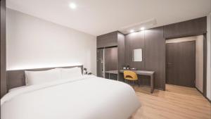 a bedroom with a white bed and a desk at HOTEL lantana in Tudomi +14 photos