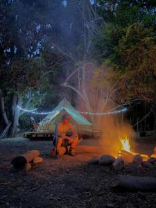a man sitting in front of a camp fire at BajaRoots Glamping in San José del Cabo
