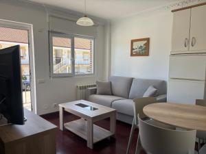 a living room with a couch and a table at Apartamentos La Reserva Isla "Playa de la Cava" in Isla
