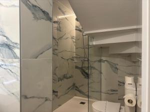 a bathroom with a glass shower with a toilet at Apartamentos La Reserva Isla "Playa de la Cava" in Isla +22 photos