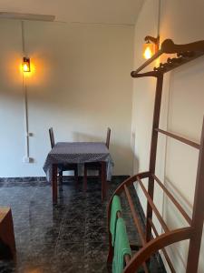 a table and chairs in a room with a table and a lamp at Inuli Coco Hut in Kalutara