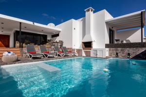 a swimming pool in front of a villa at Villa con piscina climatizada y vistas al mar in Mácher
