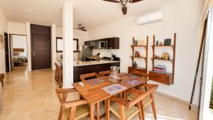 a dining room and kitchen with a wooden table and chairs at Townhome with private Rooftop & Jacuzzi - Beach across street in Akumal