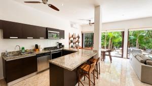 a kitchen with a counter and a living room at Townhome with private Rooftop & Jacuzzi - Beach across street in Akumal