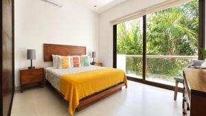 a bedroom with a bed and a large window at Townhome with private Rooftop & Jacuzzi - Beach across street in Akumal