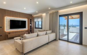 a living room with a couch and a tv at Serenya Hotel Milos in Adamantas