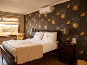 ein Schlafzimmer mit einem Bett und einer Wand mit Blumen in der Unterkunft Hotel Pitrufquen in Pitrufquén