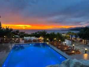 a pool with a view of the ocean at sunset at Vila Bello in Ksamil