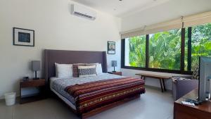 a bedroom with a bed and a large window at Townhome with private Rooftop & Jacuzzi - Beach across street in Akumal