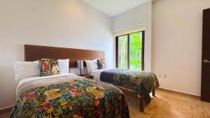 a hotel room with two beds and a window at Townhome with private Rooftop & Jacuzzi - Beach across street in Akumal +12 photos